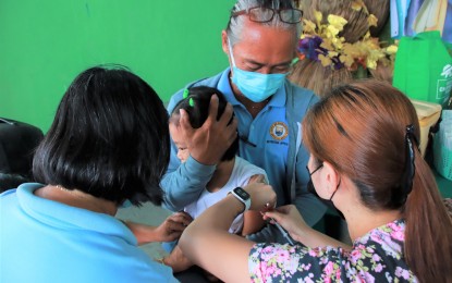 <p><strong>‘CHIKITING LIGTAS’</strong>. A health worker gives the measles-rubella shot to a child at the Barangay Batinguel covered court in Dumaguete City, Negros Oriental on Tuesday (May 2, 2023). The Provincial Health Office said it is targeting 148,201 children to be vaccinated against the diseases as part of a mass immunization program.<em> (Photo courtesy of the City PIO/Lupad Dumaguete Facebook)</em></p>