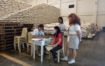 <p><strong>RICE ASSISTANCE</strong>. A government worker claims her sack of rice at the National Food Authority warehouse in Laoag City on April 19, 2023 during the soft launching of the one-time rice assistance program for government workers nationwide. The Department of Budget and Management released a total of PHP1.182 billion for the NFA to implement the program. <em>(Photo courtesy of NFA Ilocos Norte)</em></p>