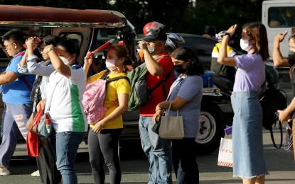 <p><strong>THE HEAT IS ON.</strong> Commuters wait for a ride under the sweltering heat along Elliptical Road in Quezon City on Thursday (May 4, 2023). Some use fans to provide temporary shade from direct sunlight. <em>(PNA photo by Joan Bondoc)</em></p>