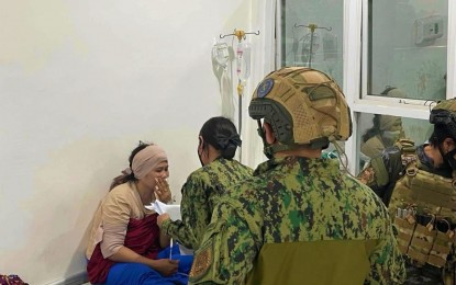 <p><strong>ARRESTED</strong>. A police officer reads the warrant of arrest for multiple frustrated murder against Racma Dinggo Hassan at her hospital bed in Isulan, Sultan Kudarat, on Sunday (May 7, 2023). The suspect is tagged as the finance officer of the Dawlah Islamiya terrorist group operating in Central Mindanao. <em>(Photo courtesy of Raja Buayan MPS)</em></p>