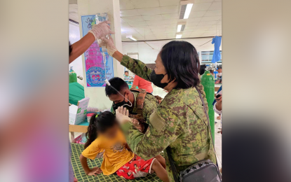 <p><strong>EXTRA HELP.</strong> Soldiers carry one of the schoolchildren who experienced dizziness after being exposed to insecticides sprayed onto coconut trees near their school in Upi, Maguindanao del Norte, on Wednesday (May 10, 2023). At least 100 schoolchildren at the Mirab Elementary School were affected. <em>(Photos courtesy of Datu Blah District Hospital)</em></p>