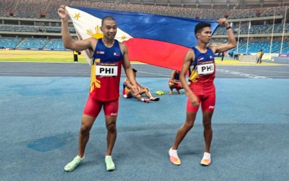 <p><strong>GOLD AGAIN</strong>. Umajesty Williams and Michael del Prado parade the national flag after surprising victory in the men’s 4x400 meter event in the 32nd Southeast Asian Games at the Morodok Techno National Stadium in Phnom Penh on Friday night (May 12, 2023). The Philippines last won the 4x400 in the Myanmar 2013 SEA Games. <em>(Contributed photo)</em></p>