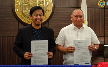 <p><strong>MONORAIL OR LRT.</strong> Lapu-Lapu City Mayor Junard Chan (left) shows the memorandum of understanding he signed on behalf of the city government and Future of Transport (Futran) Philippines, Inc. President Jose Christopher Fornier II on Thursday (May 11, 2023). Chan said on Friday that the city will adopt either Monorail or Light Rail Transit (LRT) as a modern mode of mass transport system to cope with the growing number of tourist arrivals and working population. (Photo courtesy of Lapu-Lapu City PIO)</p>