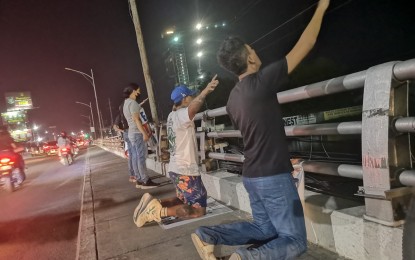 <p><strong>PRAY OVER.</strong> Members of a religious organization pray over Cagayan de Oro City's Marcos Bridge on Monday night (May 8, 2023) as a way to spread awareness on suicide prevention among the youth. Reports said teenagers have attempted or committed suicide by jumping off towards the Cagayan River. <em>(Photo courtesy of Rhyan Casiño)</em></p>