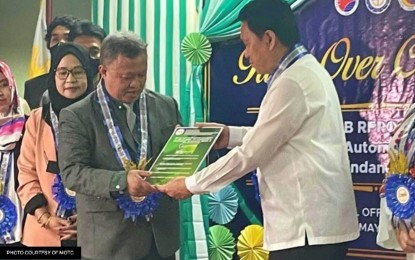 <p><strong>TRANSFER OF RESPONSIBILITIES.</strong> Land Transportation Franchising and Regulatory Board chair Teofilo Guadiz III (right) hands over the tasks and digital copies of franchise documents for Bangsamoro LTFRB from LTFRB Region 12 to Transportation Minister Paisalin Tago at the national office in Quezon City on Friday (May 12, 2023). The BLTFRB vowed to collaborate with counterparts across the country regarding the franchising of public land transportation services.<em> (Photo from MOTC-BARMM)</em></p>