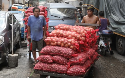 <p><strong>GO LOCAL.</strong> A porter pushes a cart loaded with red onions in Binondo, Manila on Tuesday, May 16, 2023. The Department of Agriculture on Monday (May 20, 2024) said it is set to extend the existing importation ban on onion as the supply of the agricultural product remains stable. <em>(PNA file photo by Yancy Lim)</em></p>