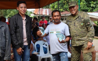 <p><strong>CASH ASSISTANCE.</strong> Melesio Magalasin (center), chairperson of the Nagkahiusang Mag-uumang Lumad of Sitio Binuhi in San Isidro, Davao del Norte, shows the PHP100,000 cash assistance from the provincial government of Davao del Norte and the 1001st Infantry Brigade on Wednesday (May 17, 2023). With him are Jemuel Melmida, the executive assistant of Governor Edwin Jubahib (left), and Lt. Col. Merrill Sumalinog, the Army’s 60th Infantry Battalion commanding officer. <em>(Photo courtesy of 60IB)</em></p>