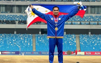 <p><strong>LONG JUMP CHAMPION</strong>. Gold medalist Janry Ubas holds the Philippine flag during the awarding ceremony of the men's long jump competition in the 32nd SEA Games in Cambodia on May 9, 2023. He will lead the national team in the Taiwan Open on May 27-28. <em>(Contributed photo)</em></p>