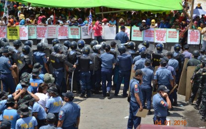 <p><strong>CALM BEFORE THE STORM.</strong> Police and protesters face off before a violent clash outside a church in Kidapawan City, North Cotabato on April 1, 2016. The protesters, mostly farmers who were demanding assistance, were cleared of assault charges by a Kidapawan court on May 18, 2023.<em> (PNP file photo)</em></p>