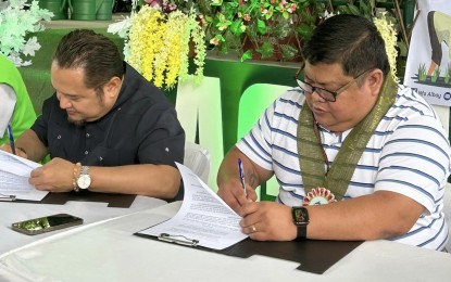 <p><strong>HIGHER BUYING PRICE.</strong> Albay Governor Edcel Greco Lagman (left) and National Food Authority-Bicol Regional Manager Osmundo R. Guinto Jr. sign on Monday (May 29, 2023) a memorandum of agreement that will raise the buying price of palay in the province. The provincial government of Albay will add a premium of PHP3 per kilogram to the NFA palay buying price of PHP19, allowing farmers to sell their palay at PHP22 per kilo. <em>(Photo courtesy of NFA-Albay)</em></p>