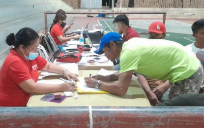 <p><strong>PAYOUT</strong>. A social worker from DSWD Field Office Mimaropa hands over the cash assistance to a beneficiary during the payout activity of the Emergency Cash Transfer for oil spill victims in Roxas, Oriental Mindoro on Thursday (June 1, 2023). Over PHP127.7 million will be distributed to some 14,291 individuals affected by the oil spill. <em>(Photo courtesy of DSWD)</em></p>