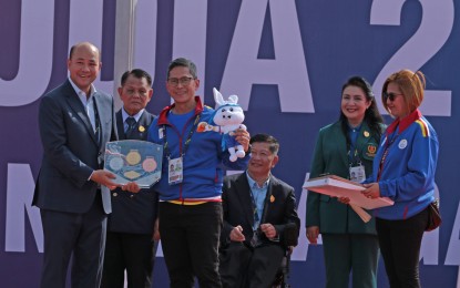 <p><strong>EXCHANGE OF SOUVENIRS:</strong> Team Philippines chef-de-mission Walter Francis Torres (third from left) presents a Philippine handicraft to Union of Youth Federations of Cambodia and National Paralympic Committee of Cambodia (NPCC) Board of Directors Vice President Hun Many (left) during the 12th ASEAN Para Games team welcome ceremony at the Morodok Techo National Stadium in Phnom Penh on June 2, 2023. Also in photo is Team Philippines deputy chef-de-mission Irene Remo (far right). <em>(Pool photo)</em></p>