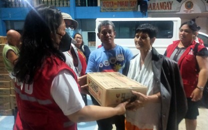 <p><strong>ASSISTANCE</strong>. A Department of Social Welfare and Development (DSWD) worker hands over a family food pack to a victim of flooding in Barangay Bakhaw in Iloilo City on Thursday (June 1, 2023). As of June 1, the DSWD and concerned local government units have provided over PHP1.15 million worth of assistance to families displaced by the inclement weather. <em>(Photo courtesy of DSWD 6)</em></p>