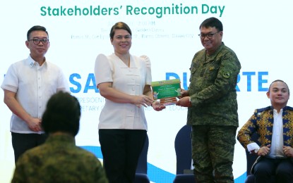 <p><strong>RECOGNITION.</strong> Vice President and Education Secretary Sara Z. Duterte (center) hands over the plaque of appreciation to Lt. Gen. Greg Almerol, commander of the Eastern Mindanao Command, in simple rites in Davao City on Sunday (June 4, 2023). Duterte personally thanked the Armed Forces of the Philippines for helping teaching and non-teaching personnel of the Department of Education in the Bangsamoro Autonomous Region in Muslim Mindanao during the observance of Ramadan from March to April. <em>(PNA photo by Robinson Ninal Jr.)</em></p>