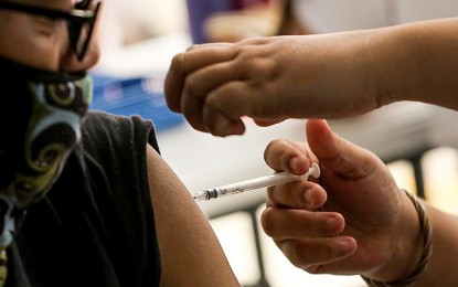 <p><strong>COVID-19 VAX.</strong> A healthcare worker administers a Covid-19 vaccine in this undated photo. The Department of Health said about 95.30 percent of the 390,000 donated doses of bivalent vaccine against coronavirus disease 2019 have been administered to priority population groups. <em>(PNA photo by Joan Bondoc)</em></p>