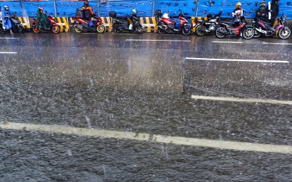 <p><strong>RAIN SHOWERS.</strong> Motorcycle riders wait for the rain to stop as they park by the roadside in Quezon City on Tuesday (June 6, 2023). Tropical Storm Chedeng will enhance the southwest monsoon (<em>habagat</em>) but is unlikely to bring heavy rains in the next three to five days as it is forecast to remain far from land mass, the weather bureau said. <em>(PNA photo by Joan Bondoc)</em></p>