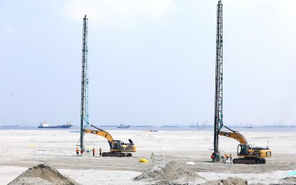 <p><strong>RECLAMATION</strong>. Workers load construction plastic rolls onto a heavy equipment vehicle at a reclamation area in Manila Bay in Pasay City on June 5, 2023. ACT-CIS Party-list Rep. Erwin Tulfo is seeking an investigation into the status of the Manila Bay reclamation projects and their effects on national security and the environment. <em>(PNA file photo)</em></p>