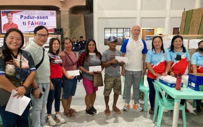 <p><strong>PAYOUT.</strong> Some of the 999 Tulong Panghanapbuhay sa Ating Displaced/Disadvantaged Workers (TUPAD)  workers in Vintar, Ilocos Norte receive their payments at the Vintar auditorium on Wednesday (June 7, 2023) after rendering community service in their respective villages. Vintar Mayor Richard Degala (in white and blue shirt), along with DOLE representatives, facilitates the payments.  <em>(Photo courtesy of Vintar LGU)</em></p>