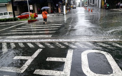 <p><strong>WET.</strong> A pedestrian crosses a portion of Kamuning, Quezon City on Sunday (June 11, 2023). Typhoon Chedeng is forecast to leave the Philippine Area of Responsibility at night but the enhanced southwest monsoon (habagat) will bring occasional rains. <em>(PNA photo by Joan Bondoc)</em></p>