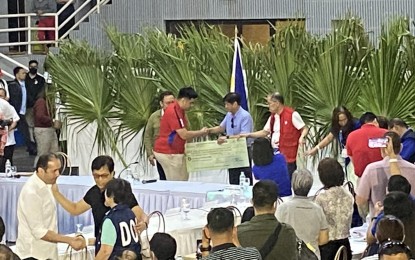 <p><strong>GOV'T ASSISTANCE.</strong> Guinobatan Mayor Paul Chino Garcia (red) receives from President Ferdinand R. Marcos Jr. on Wednesday night (June 14, 2023) the initial government assistance that will be used for the emergency employment of evacuees through the Tulong Panghanapbuhay sa Ating Disadvantaged / Displaced Workers (TUPAD) of Department of Labor and Employment. A family member will be engaged in TUPAD for PHP10,950 within 30 days. <em>(PNA photo by Connie Calipay)</em></p>