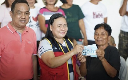 <p><strong>CASH AID.</strong> A Ligao City resident (right) who is among those affected by Mayon Volcano's restiveness receives government cash aid from a DSWD personnel (center) and Albay Rep. Fernando Cabredo (left) on Friday (June 16, 2023). The PHP5,000 cash assistance for each of 869 families from Ligao City and Guinobatan in Albay province is under the Assistance to Individuals in Crisis Situation program. <em>(Photo courtesy of Rep. Cabredo)</em></p>