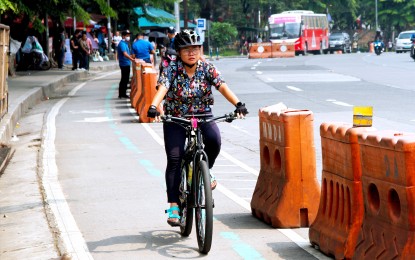 <p><strong>BIKE LANE.</strong> A young woman uses the bike lane along Elliptical Road in Quezon City on June 19, 2023. The Department of Health on Friday (May 10, 2024) said such active transport infrastructure programs will help reduce the number of road crash casualties by reducing the number of cars on the road and providing protection to cyclists and pedestrians.<em> (PNA photo by Jess M. Escaros Jr.)</em></p>