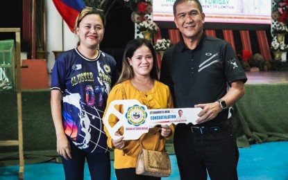 <p><strong>FREE HOUSING.</strong> Mayor Roderick Furigay of Lamitan City, Basilan (right) hands over a key replica to a recipient of a free housing unit during a raffle draw held at the city's gymnasium earlier this month. The beneficiaries of the housing program are indigents affected by road widening projects, floods and river bank dwellers. <em>(Photo courtesy of Lamitan CIO)</em></p>