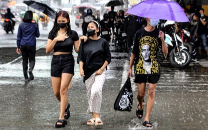 <p><strong>UNBOTHERED.</strong> These women seem to enjoy the rain as they walk along Kamuning in Quezon City on June 20, 2023. Most parts of Luzon will experience rain showers due to the “habagat,” according to the weather bureau. <em>(PNA photo by Joan Bondoc)</em></p>