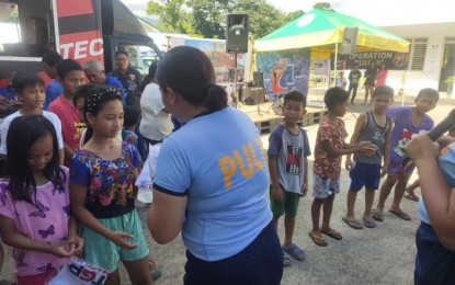 <p><strong>MENTAL HEALTH CARE.</strong> A police officer on Tuesday (June 19, 2023) conducts a simple game for children temporarily staying at the San Antonio Evacuation Center in Tabaco City in Albay province. The Police Regional Office in Bicol (PRO5) is playing an active role in the lives of evacuees through psychosocial intervention measures under the "Oplan Kasurog kan Bakwit" Program. <em>(Photo courtesy of PRO5)</em></p>