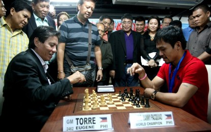 <p><strong>HALL OF FAMER.</strong> Eugene Torre (seated left), Asia's first grandmaster and world Hall of Famer, plays against former eight-division world boxing champion Manny Pacquiao in a tournament in 2018. Torre has been invited to play a simultaneous game during the "Asenso Misamis Occidental National Open" on July 8-9, 2023 in Ozamiz City. <em>(Contributed photo)</em></p>