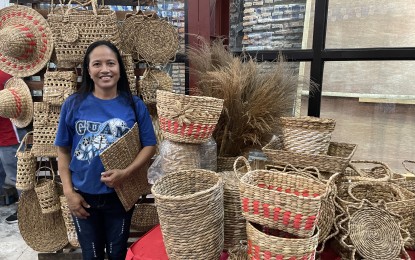 <p><strong>EXPORT QUALITY</strong>. Cathy Baided, president of the Cataban Weavers Association in Laoag, Ilocos Norte, sells novelty items made from water lilies at a city trade fair from June 20 to 21, 2023. Custom-made products are also available upon request. <em>(Photo by Leilanie G. Adriano)</em></p>