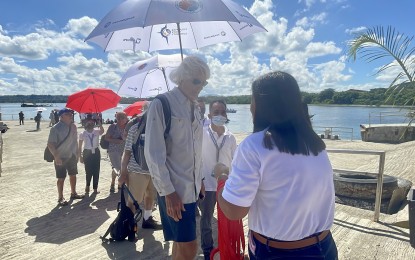 <p><strong>WELCOME LEIS</strong>. Arriving guests receive welcome lei from the Department of Tourism at the Currimao Seaport in Ilocos Norte on Monday (June 26, 2023). More cruise lines are expected to arrive this year at the port. <em>(Photo by Leilanie G. Adriano)</em></p>