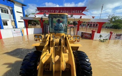 <p><strong>FLOOD TRANSPORT. </strong>A payloader served as the lone transporter of local government employees of Pagalungan, Maguindanao del Sur on Thursday (June 29, 2023).  The municipal hall grounds have been underwater since Monday, although the water has receded a bit as of Thursday morning. <em>(Photo courtesy of MILG-BARMM)</em></p>