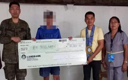 <p><strong>CASH GRANT</strong>. A former rebel (in blue shirt) receives a check for the cash grant through the Enhanced Comprehensive Local Integration Program (ECLIP), in this undated photo. The Visayas Command reported on Friday (June 30, 2023) that 109 former members of the New People's Army received a total of PHP5.5 million worth of cash assistance through ECLIP for the first semester of 2023. <em>(Photo courtesy of Viscom PIO)</em></p>