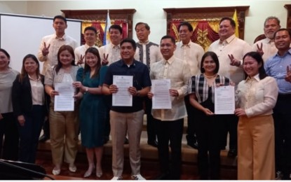 <p><strong>APPROVED.</strong> Pangasinan Gov. Ramon Guico III (fifth from left), together with the members of Sangguniang Panlalawigan, pose after the regular session on Monday (July 10, 2023). The provincial officials hold a copy of the resolution authorizing Guico to enter an agreement with the San Miguel Holdings Corporation for the construction of phase one of the Pangasinan Link Expressway project<em>. (PNA photo by Liwayway Yparraguirre)</em></p>