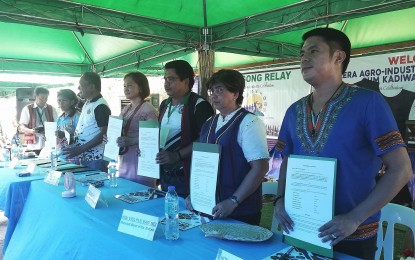 <p><strong>OFW CARE</strong>. Local government units in Apayao and the Department of Migrant Workers (DMW) show the signed memorandum of agreement for the establishment of overseas Filipino workers’ help desks in the municipalities, during the “Kadiwa ng Pangulo” agro-industrial fair in Luna, Apayao on Thursday (July 13, 2023). DMW Regional Director Luzviminda Dimaliuan said the signing was a renewal of the partnership between the DMW and the local governments to better serve modern-day heroes, especially those in distress. <em>(PNA photo by Liza T. Agoot)</em></p>