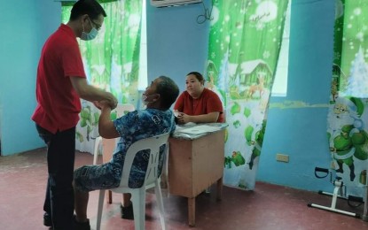 <p><strong>SPECIAL CARE</strong>. A healthcare worker in Batangay Cotta, Lucena City is seen in this undated photo extending free medical service to an elderly resident at a wellness center that is also manned by doctors and trained therapists. The barangay now also gives a PHP500 birthday gift to seniors and persons with disability.<em> (PNA photo by Belinda Otordoz)</em></p>