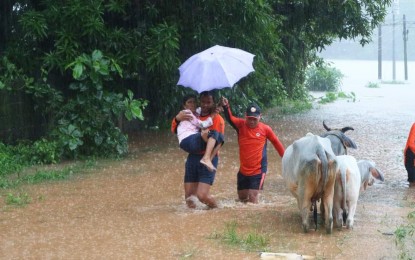 <p><strong>RESCUE.</strong> A personnel of the Philippine Coast Guard carries a resident while being evacuated in Alaminos City, Pangasinan on Saturday (July 15, 2023). A total of 19 families were evacuated in the morning due to flooding caused by Tropical Storm Dodong. (Photo courtesy of Alaminos LGU)</p>