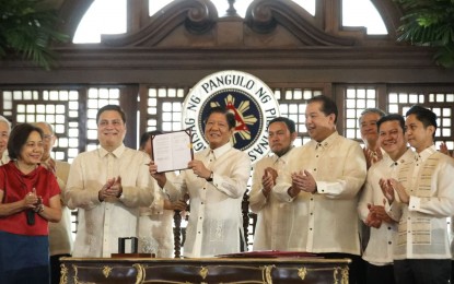 <p><strong>MIF ACT.</strong> President Ferdinand R. Marcos Jr. shows the signed copy of Republic Act 11954 or the Maharlika Investment Fund Act of 2023, at the Kalayaan Hall of Malacañan Palace in Manila on Tuesday (July 18, 2023). The establishment of the MIF will provide the government with a long-term source of income, as well as ease the burden on the national budget by providing additional funding for other priority projects of the government. <em>(PNA photo by Rolando Mailo)</em></p>