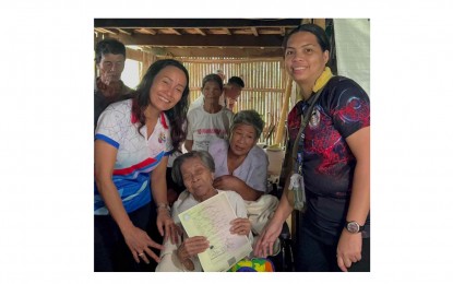 <p><strong>BIRTH CERTIFICATE</strong>. Enriquita Quillano Olitan, a 101-year-old woman from Kabankalan City, Negros Occidental, receives her birth certificate from OIC City Civil Registar Monalisa Tabujara (left) and PhilSys Birth Registration Assistance Program (BPRAP) agent Jesirie Marie Gedorio at her residence in Barangay Tampalon on July 13, 2023. She was able to finally register her birth and obtain a certificate for free under the BPRAP being implemented by the Philippine Statistics Authority. <em>(Photo courtesy of PSA-Negros Occidental)</em></p>