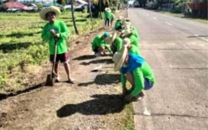 <p><strong>EMERGENCY EMPLOYMENT.</strong> Beneficiaries of the Tulong Panghanapbuhay sa Ating Disadvantaged /Displaced Workers (TUPAD) program clean the area along the highway in the municipality of Sebaste on July 7, 2023. Philippine Councilors League Antique Chapter president Plaridel Sanchez IV said in an interview Wednesday (July 19, 2023) some 1,556 parents were recipients of the emergency employment program. (<em>PNA photo courtesy of DOLE Antique</em>)</p>