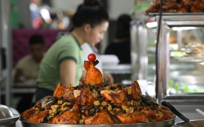 <p><strong>TOURIST-FRIENDLY</strong>. A food attendant sells a variety of halal food, including biryani for PHP140 per order, in Malate, Manila in this 2023 photo. Biryani is a mixed rice dish with chicken, beef, or fish, vegetables, and spices. <em>(PNA file photo by Yancy Lim)</em></p>