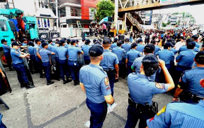 <p><strong>READY TO SECURE. </strong>Cops are on standby near the protesters along Commonwealth Avenue, Quezon City in this photo taken on July 24, 2023. The Philippine National Police (PNP) said Wednesday (June 26, 2024) it has begun security preparations for the 2025 midterm elections. <em>(PNA photo by Ben Briones)</em></p>