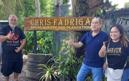 <p><strong>AGRITOURISM SITE</strong>. Bago City Mayor Nicholas Yulo (2nd from right) and senior tourism operations officer Mae Ann Furtos with award-winning Negrense cacao farmer Christopher Fadriga (left) at the Chris Fadriga Cacao Nursery and Plantation in Barangay Atipuluan on July 21, 2023. A signage was put up at the farm site as assistance under the city’s “Booming Green Agritourism” program.<em> (Photo courtesy of Bago City Information Office)</em></p>