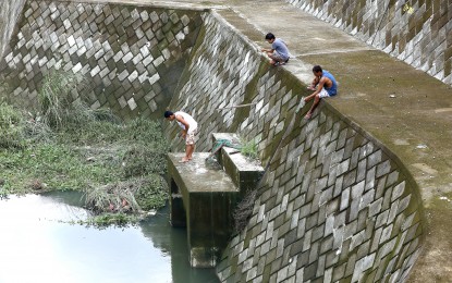 <p><strong>CATCHING FISH</strong>. Residents try their luck in catching tilapia at a retarding basin in Barangay Buhay na Tubig, Imus, Cavite on Monday (July 31, 2023), following days of heavy downpours due to Super Typhoon Egay and the southwest monsoon enhanced by Typhoon Falcon. Retarding basins store most of the rainwater run-off during high rainfall to absorb and contain flooding and later release it at a regulated flow rate. <em>(PNA photo by Yancy Lim)</em></p>