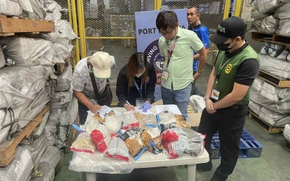 <p><strong>BUSTED. </strong>Operatives of the Philippine Drug Enforcement Agency (PDEA) and the NAIA-Inter-Agency Drug Interdiction Task Group (IADITG) examine a parcel containing PHP45.9 million worth of shabu in Pasay City on Wednesday (Aug. 2, 2023). The PDEA said the parcel with airway bill number 176-57120103 declared as "African Cultura" was shipped by a certain Michael Mobida from Johannesburg, South Africa and is consigned to a certain Wilbert Dee. <em>(Photo courtesy of PDEA)</em></p>