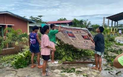 <p><strong>SCHOOL AID</strong>. Students of Eladio V. Barangan Memorial Elementary School help clean their school on July 30, 2023 after Typhoon Egay swept northern Luzon. In support of farmers' dependents affected by the typhoon, Senator Imee Marcos has offerred them educational assistance. <em>(Contributed photo)</em></p>