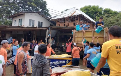 <p><strong>BAYANIHAN</strong>. Police, disaster management personnel and barangay officials load relief goods into a truck as they prepare to distribute them to the flooded residences in Calasiao town, Pangasinan on Thursday (Aug. 2, 2023). Calasiao, as a catch basin in Pangasinan, remains flooded in the aftermath of Typhoon Egay and the enhanced southwest monsoon. <em>(Photo courtesy of Calasiao MDRRMO)</em></p>