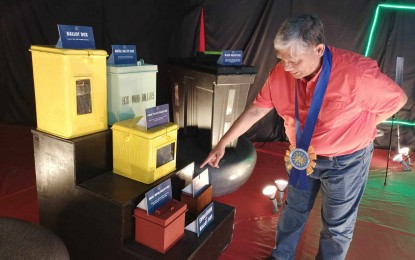 <p><strong>ELECTIONS EXHIBIT</strong>. Commission on Elections (Comelec) Regional Director for Western Visayas Atty. Dennis Ausan points to some of the early ballot boxes used in the conduct of elections in the country as part of the exhibit mounted by the agency at the Robinsons Place Jaro from Aug. 8 and 9. In an interview, he said the exhibit aims to enhance public interest to exercise their right to vote. <em>(PNA photo by PGLena)</em></p>