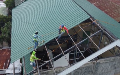 <p><strong>SCHOOL REPAIR.</strong> Workers hired by the Cebu City Local School Board (LSB) repair damaged roofing on one of the 107 public schools in this undated photo. LSB head Ian Hassamal on Wednesday (Aug. 16, 2023) said three of the 107 public schools have ongoing repairs and the rest are ready for the opening of classes on Aug. 29. <em>(Screenshot from Cebu City PIO video)</em></p>